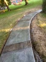Custom colored granite stamped walkway accented with multi-colored stained bands of ashlar slate